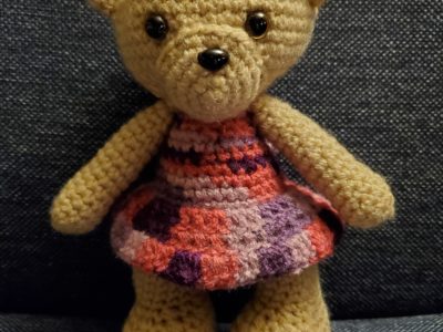 small stuffed bear with dress and bow (front)